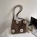 Détail d'un sac cabas en feutre marron avec broderie fleurie blanche et anses en cuir - Café