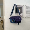 Detailed close-up of navy functional crossbody bag with color-block pockets and embroidery - Blue