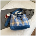 Detail der blauen karierten Canvas-Hobo-Tasche mit Kordelzug und Bären-Anhänger - Blau mit Anhänger / Blau mit Anhänger