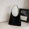 Detail der Hobo-Tasche mit dunklem Leopardenmuster und minimalistischem Trageriemen - Schwarz