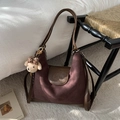 Detail van vintage bruine shopper met suède textuur en een pluche beer sleutelhanger - Koffie met Hanger