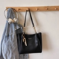 Dettaglio di borsa tote intrecciata nera con tracolla a catena e ciondolo a perle - Nero Con Pendente