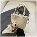 Détail du sac seau blanc à texture litchi avec un adorable pendentif en peluche pour chiot - Blanc (Avec Pendentif)