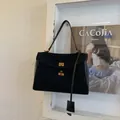 Detailed view of black suede and smooth leather tote featuring a gold twist lock closure - Black Small
