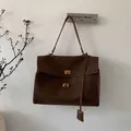 Detail of dark brown suede tote bag featuring metallic gold twist locks and retro texture - Brown Large