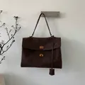 Detail of dark brown suede tote bag featuring dual golden metal twist locks and leather tag - Coffee Large