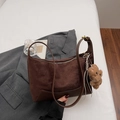 Dettaglio ravvicinato della borsa in pelle scamosciata marrone con ciondolo a orsetto - Caffè Con Ciondoli