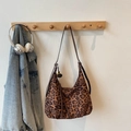 Detail der hobo-schultertasche mit leopard-print, sonnenblumen-anhänger und braunem riemen - Braun