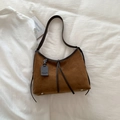 Brown faux suede tote bag with leather trim and decorative tag shown in a flat lay view - Brown