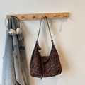 Detail der hobo-tasche mit leopard-print fransenquaste und leder-schultergurt am kleiderbügel - Dunkelbraun