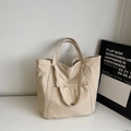 Dettaglio della grande borsa tote in tela con doppi manici e tasca esterna - Bianco Sporco