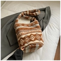Detalle de bolso tipo cubo de felpa con motivos étnicos en cama blanca con blazer - Marrón Arroz Étnico