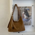 Detailaufnahme der braunen Hobo-Tasche aus strukturiertem Leder mit goldener Beschriftung - Braun