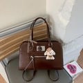 Détail d'un sac à main vintage marron foncé avec décor en métal et breloque chiot - Avec Pendentif / Bordeaux