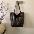 Detail of vintage dark brown faux leather tote bag with metallic decorative pendant - Coffee With Pendant