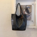 Dettaglio borsa tote grande grigio scuro in pelle con ciondolo intrecciato ed etichetta in tessuto - Nero con ciondolo