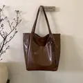 Dettaglio borsa shopper vintage marrone scuro con cinturino intrecciato e fibbia in metallo - Marrone con ciondolo