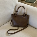 Borsa a secchiello vintage marrone in pelle sintetica con manico a nodo su un divano - Marrone senza ciondoli