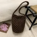 Detail of dark brown plush bucket bag with white heart dots in a cozy autumn setting - Brown