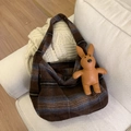 Detail of wool tote bag with striped pattern and brown leather rabbit charm on a sofa - Brown Plaid (With Pendant)