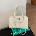 Glossy creamy white handbag with silver hardware and front zipper on a green book - No Pendant / White