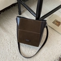 Close-up of brown suede and leather bucket bag with silver brand plaque and strap - Brown