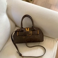 Detalle de bolso vintage marrón con hebilla dorada y correa ajustable de cuero - Marrón