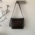 Detaillierte Seitenansicht einer minimalistischen kaffeebraunen Ledertasche mit Zierband - Braun Ohne Anhänger