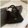 Detailed view of black suede bucket bag featuring vintage gold oval metal hardware - Black