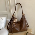Detail view of brown vintage PU leather tote bag with a knitted bear charm and gold hardware - Brown with Pendant