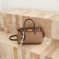 Bruine canvas en lederen bucket bag met metalen slot en decoratieve bedelhangers - Bruin met Hanger