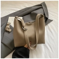 Primer plano del bolso saco caqui con textura lichi sobre un blazer gris muy moderno - Gris