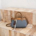 Blue denim and brown leather bucket bag with chocolate charm on stone steps - Blue with Pendant