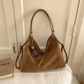 Detail van een vintage bruine suède tote tas met goudkleurige gesp en kleine beer hanger - Bruin met Hanger