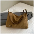 Detail der braunen Wildleder-Tragetasche mit Lederriemen in minimalistischem Ambiente - Khaki