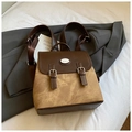 Vintage-Rucksack aus braunem Leder mit Kontrastklappe und Hasenlogo auf weißem Bett - Braun