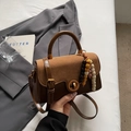 Detalle de un bolso bandolera vintage marrón con cierre giratorio y cuentas étnicas de madera - Con Colgante / Marrón
