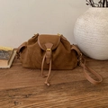 Detail of brown suede hobo bag featuring drawstring closure and vintage gold hardware - Brown