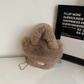 Detail einer flauschigen braunen Kunstpelztasche mit weißem Webetikett und Metallkettenband - Dunkelbeige
