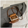 Detail of a brown mini crossbody bag featuring white lace trim and a plush baguette charm - Brown
