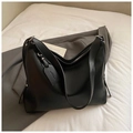 Primer plano de bolso tote negro en cuero PU con etiqueta de marca y textura de calidad - Negro