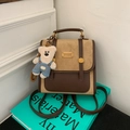 Detalle de mochila retro bicolor con textura de ante y un bonito colgante de oso - Caqui Con Colgante