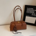 Detail der braunen Tasche mit Litchi-Leder-Textur, Goldlogo und gewebtem Tragegurt - Mit Anhänger / Braun