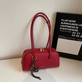Detailansicht der roten Tasche aus genarbtem Leder mit goldenem Reißverschluss und Anhänger - Mit Anhänger / Burgunderrot