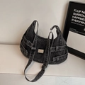 Detailweergave van zwarte denim crossbodytas met metalen logo en decoratieve gespriemen - Zwart