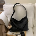 Detail of a vintage black Hobo shoulder bag with a woven strap and a cute brown bear charm - Black With Pendant
