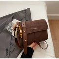 Dettaglio della borsa a spalla in pelle scamosciata marrone con ciondolo e logo in metallo - Con Ciondolo / caffè