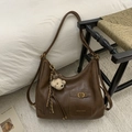 Detail of dark brown leather hobo bag with gold buckle, brand logo and bear charm - Brown with Pendant