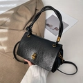 Detail of black pleated faux leather handbag with golden twist lock and braided handle - Black
