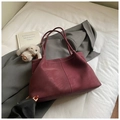 Detail of burgundy tote bag with white contrast stitching and minimalist leather handles - With Pendant / Red
